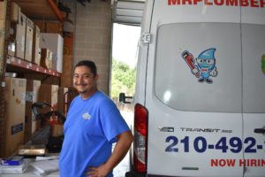 a smiling Mr. Plumber employee standing next to a company vehicle