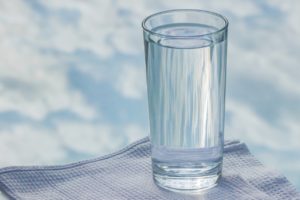 a clear cup of water with the sky in the background