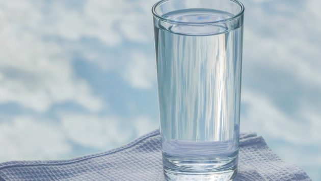 a clear cup of water with the sky in the background