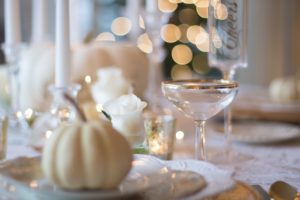 a table set with dishes and decorations for Thanksgiving