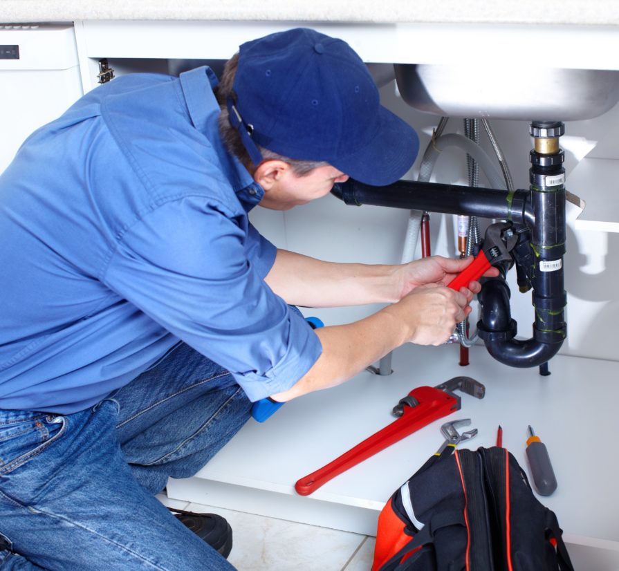 A reliable San Antonio plumber fixing damage to the pipes of a kitchen sink