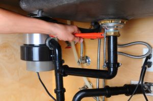 expert plumber in San Antonio using tools to perform a garbage disposal repair