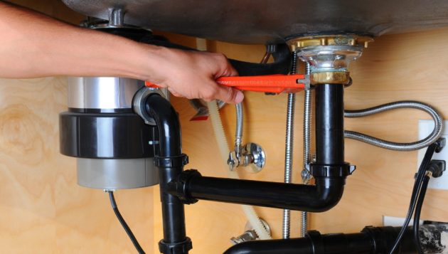 expert plumber in San Antonio using tools to perform a garbage disposal repair