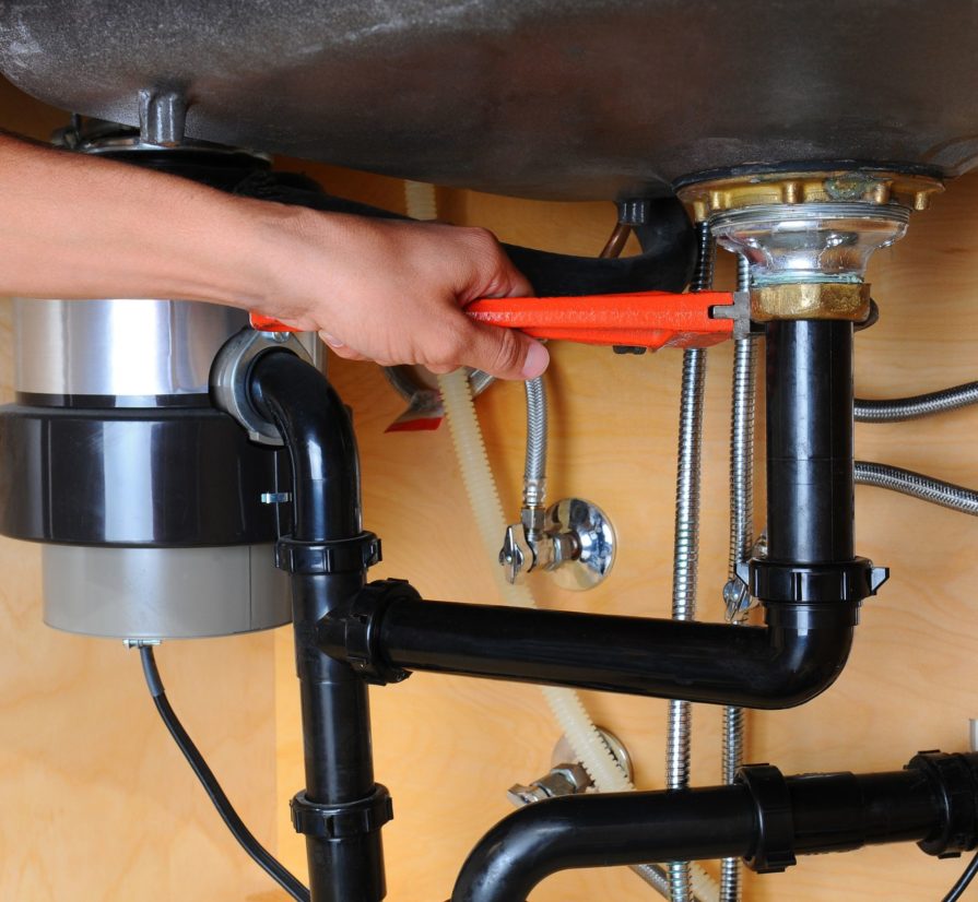 expert plumber in San Antonio using tools to perform a garbage disposal repair