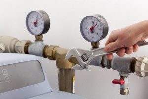 plumber repairing a water softener in San Antonio with a wrench