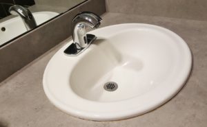 a bathroom sink with a motion detector in the faucet