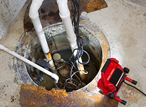sump pump in the floor of a basement going through professional plumbing repairs