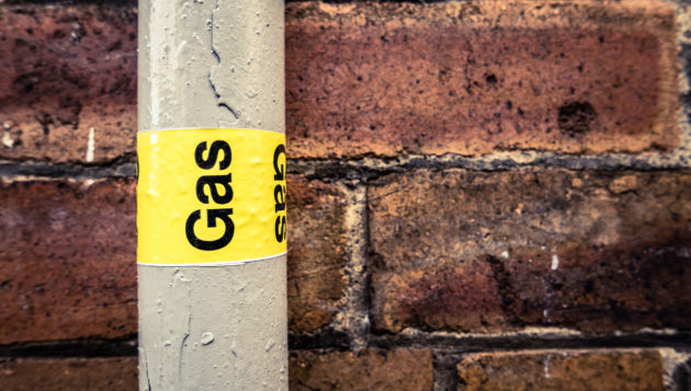 a gas line installed next to a brick wall