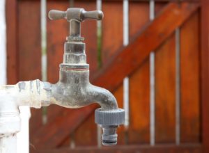 an outdoor water system with a wooden fence in the background