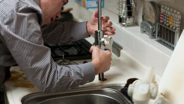 a plumber in boerne installing the faucet of a kitchen sink