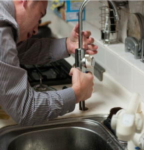 a plumber in boerne installing the faucet of a kitchen sink