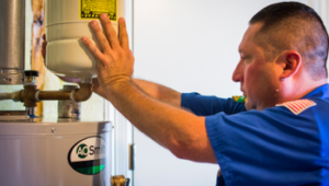 an expert San Antonio plumber adjusting a water heater to provide maintenance services