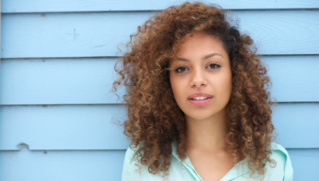 woman posing against the wall of a San Antonio home