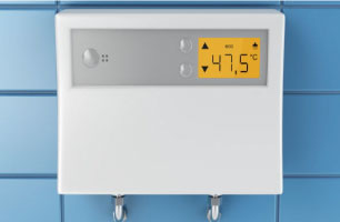 a tankless water heater installed on a wall with its temperature settings displayed