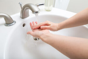 a woman washing her hands in a bathroom sink