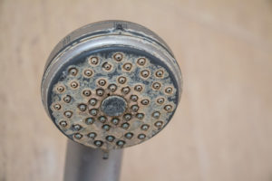 Hard water gathered on the showerhead in a residential bathroom
