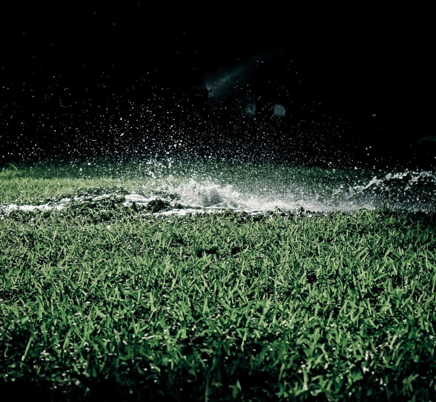 hard water splashing on a lawn during the night
