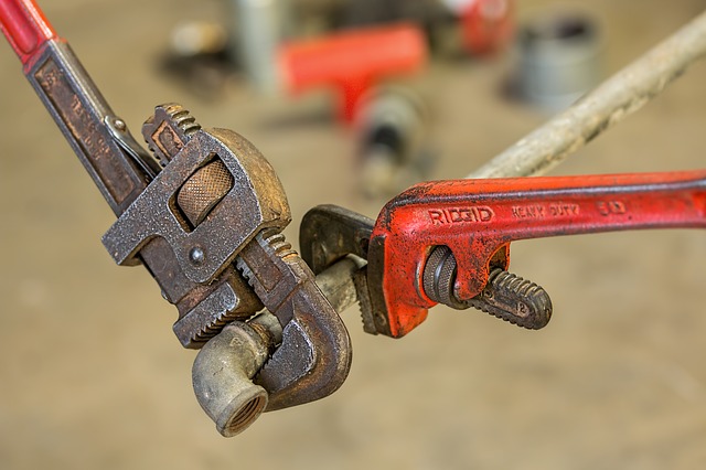 two wrenches being used to adjust a pipe