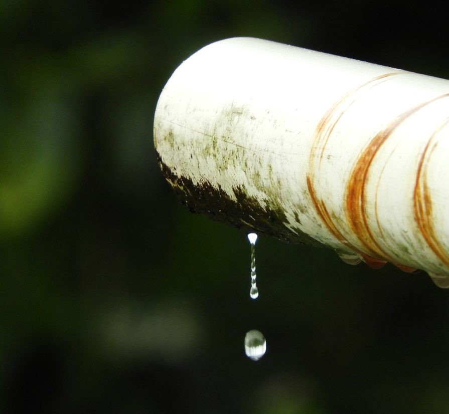 water leaking down from a dirty pipe