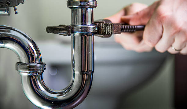 plumber fixing pipes with a wrench