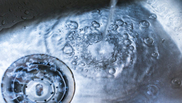 water building up in a sink due to a clogged sink