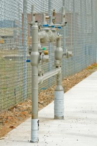 a backflow prevention system next to a fence