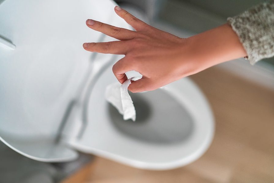 Someone throwing cotton down a bathroom toilet