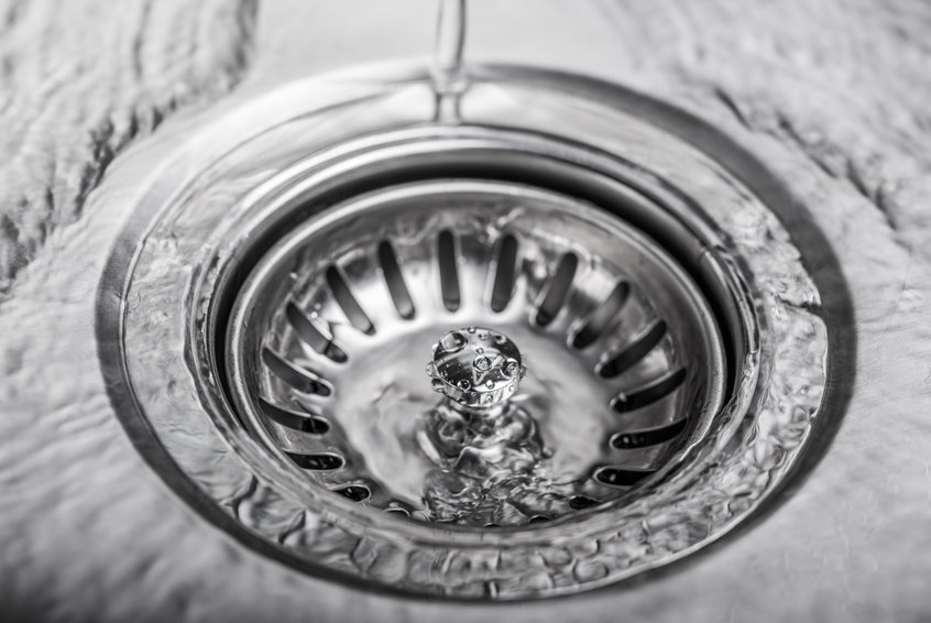 water flowing into a clean kitchen sink drain