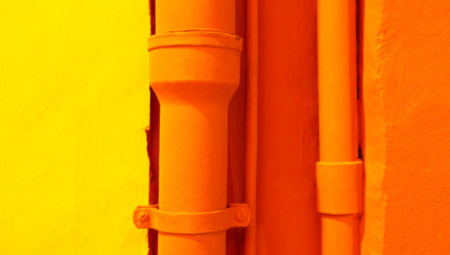 orange pipes next to a yellow wall