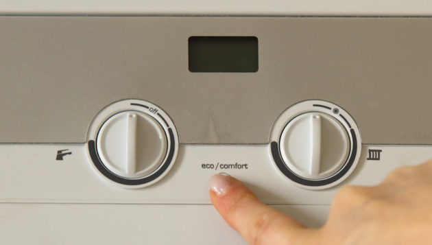 a hand adjusting the settings on a water heater