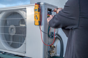 a professional service technician providing repairs to an outdoor hvac system