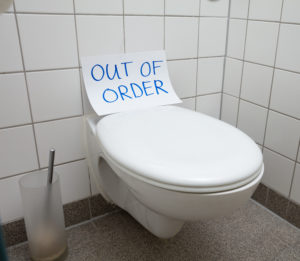 a toilet with an out of order sign on it
