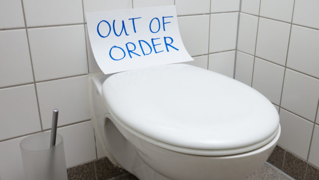 a toilet with an out of order sign on it