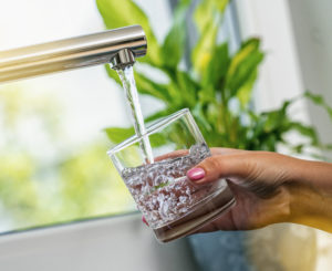 woman filling a glass with clean tap water
