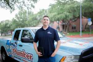 a Mr. Plumber employee standing in front of a company truck