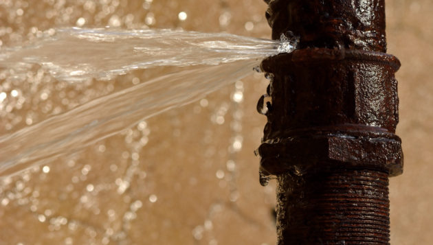 water spraying out of a burst pipe