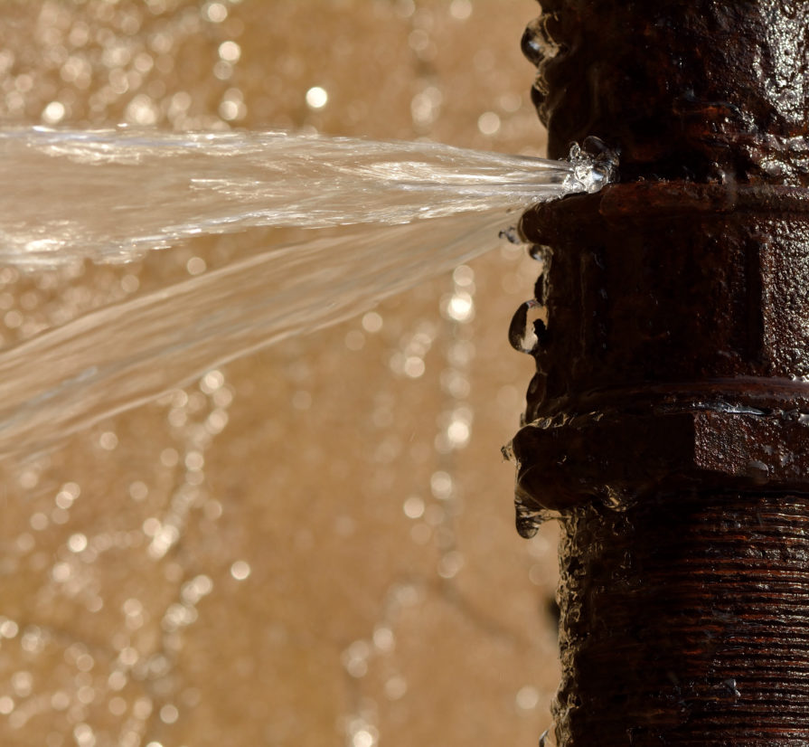 water spraying out of a burst pipe