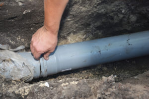 a gray sewer line being installed in the ground of a San Antonio property