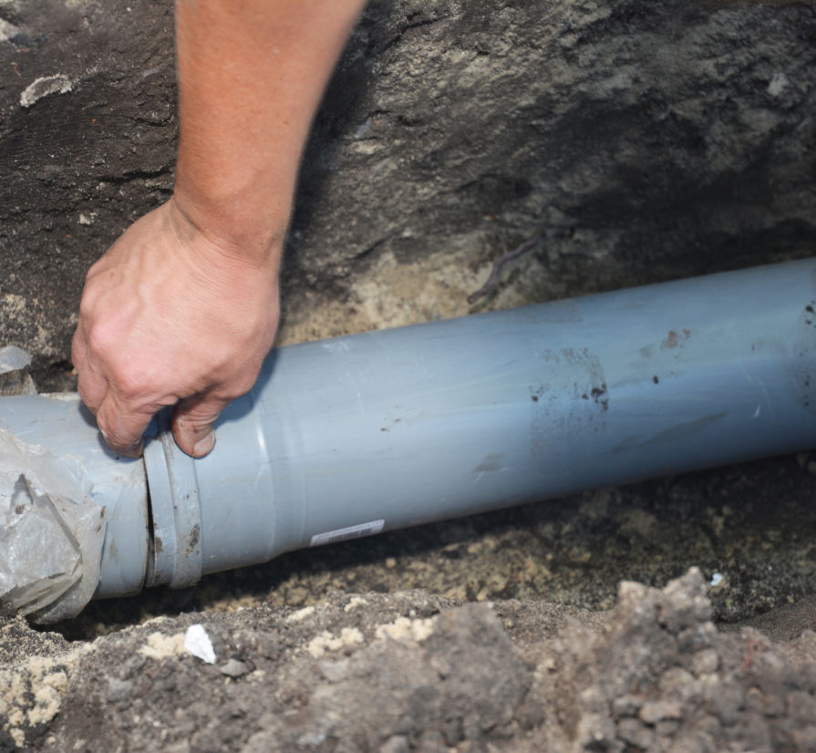 a gray sewer line being installed in the ground of a San Antonio property