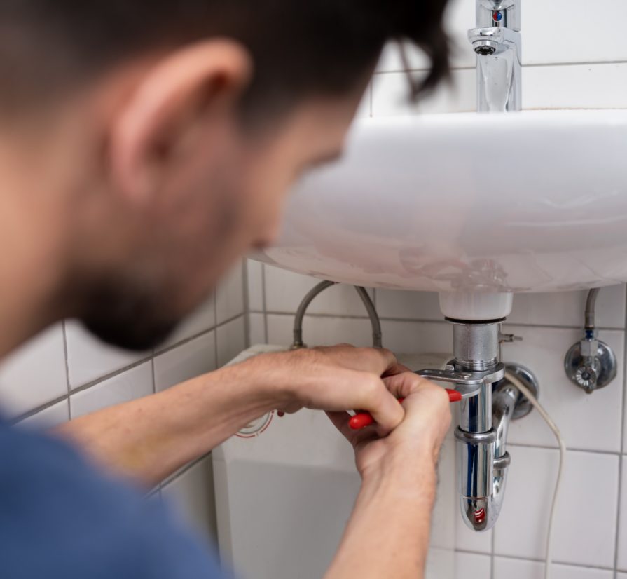 a plumber in Canyon Lake adjusting the pipes on a bathroom sink