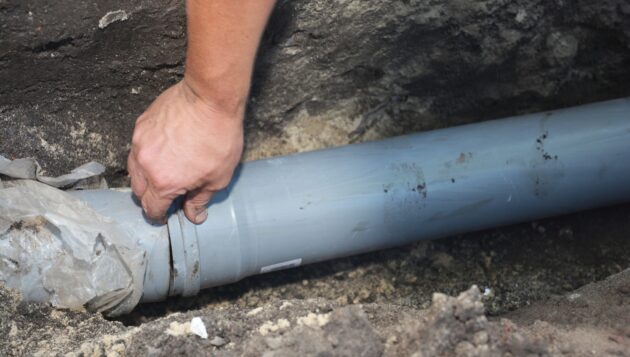 a gray sewer line being installed in the ground of a San Antonio property